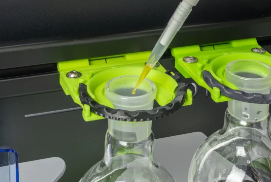 Pipette mit Tropen an Pipettenspitze über einem Rundkolben in einem SmartRack hängend