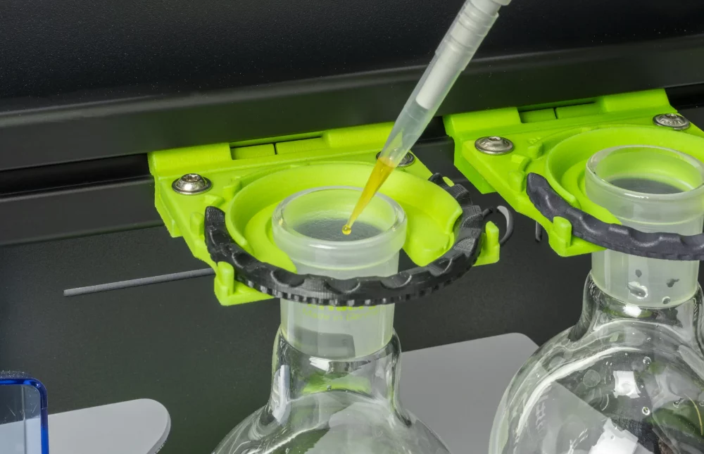 Pipette mit Tropen an Pipettenspitze über einem Rundkolben in einem SmartRack hängend